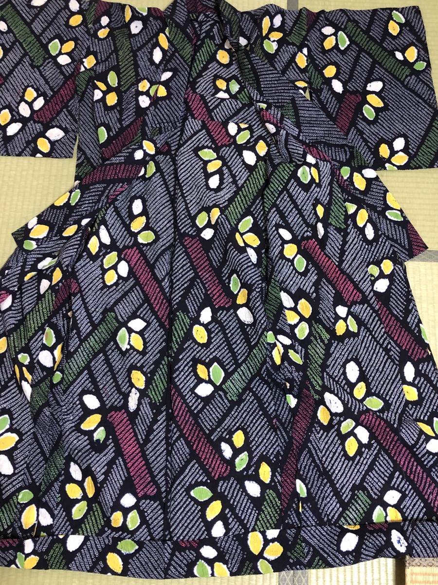Folded patterned fabric in a soft watercolour style with navy background and green, yellow and white floral stripes, calm and homely mood