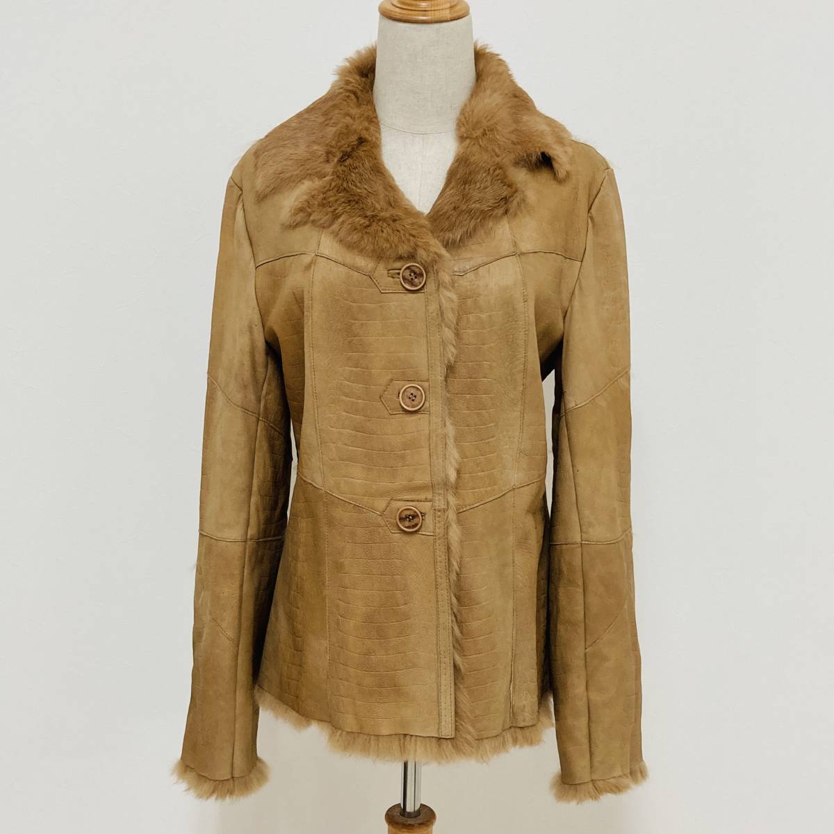 Tan suede jacket with soft fur trim and collar shown on a mannequin, rendered as a gentle watercolour with warm neutral tones